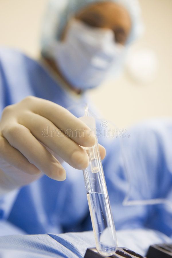 Embryologist handling a sample tube during egg retrieval