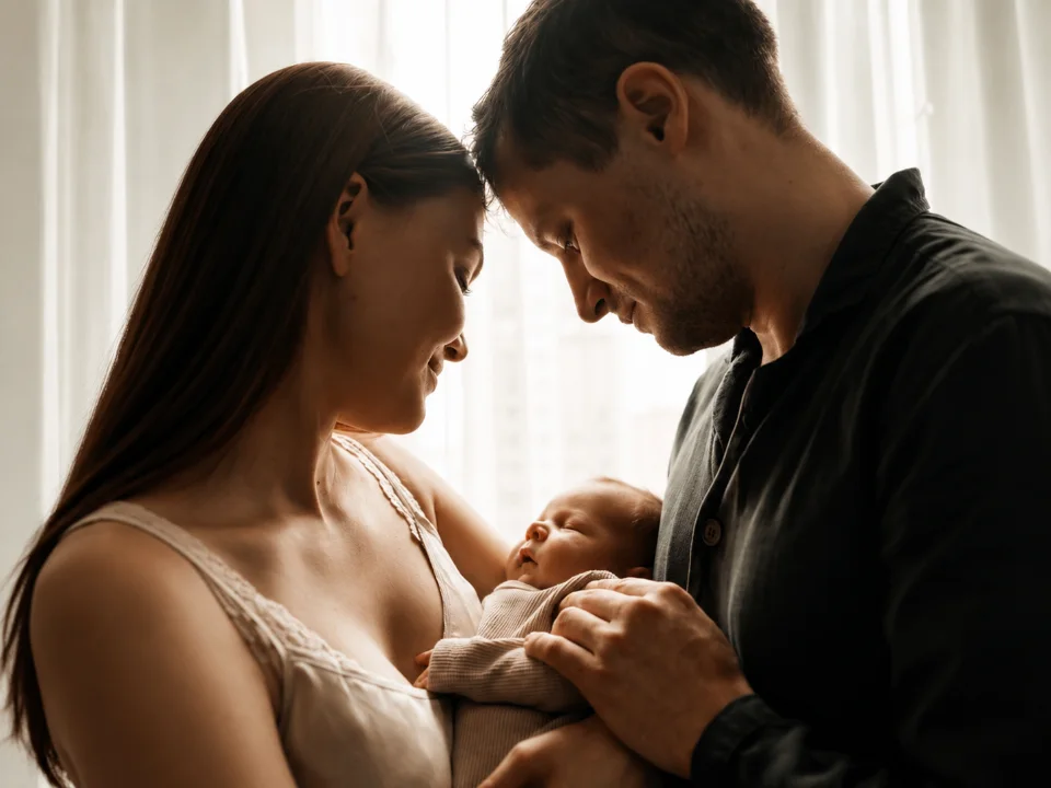 Parents holding their newborn, foreheads touching
