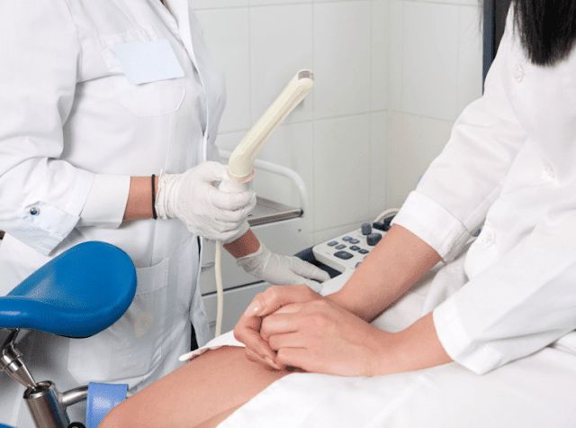 Clinician preparing a transvaginal ultrasound probe